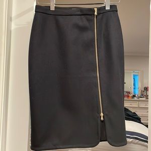 Black pencil skirt with gold front zip.